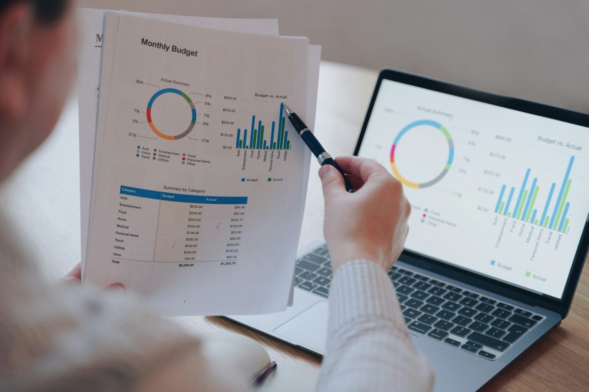 Financial round diagram on laptop screen and on paper. Man doing paperwork. Monthly budget planning.